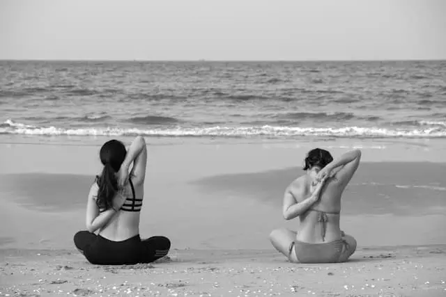 Žena cvičí jogu na pláži - relaxácia a zvládanie menopauzy