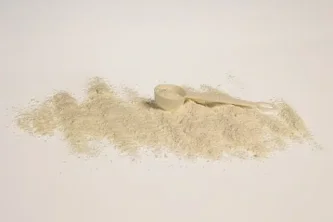 Bílý prášek objemového plnidla na lžičce