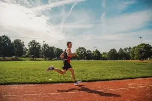Muž beží po atletickom ovále – intervalový tréning