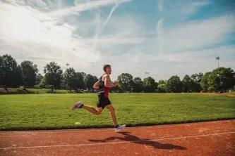Muž běží po atletickém oválu – intervalový trénink