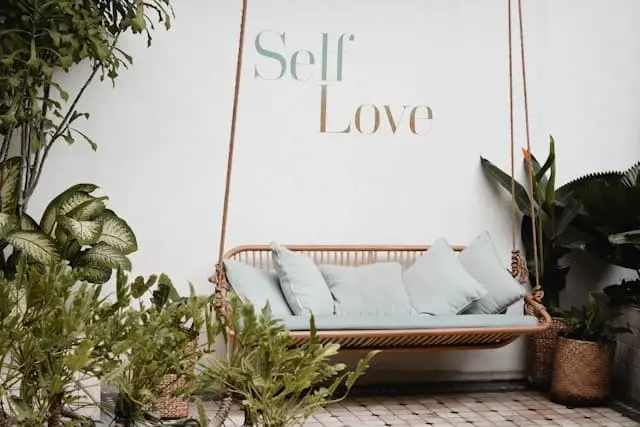 Zahradní houpačka s nápisem Self Love jako symbol odpočinku a laskavosti k sobě